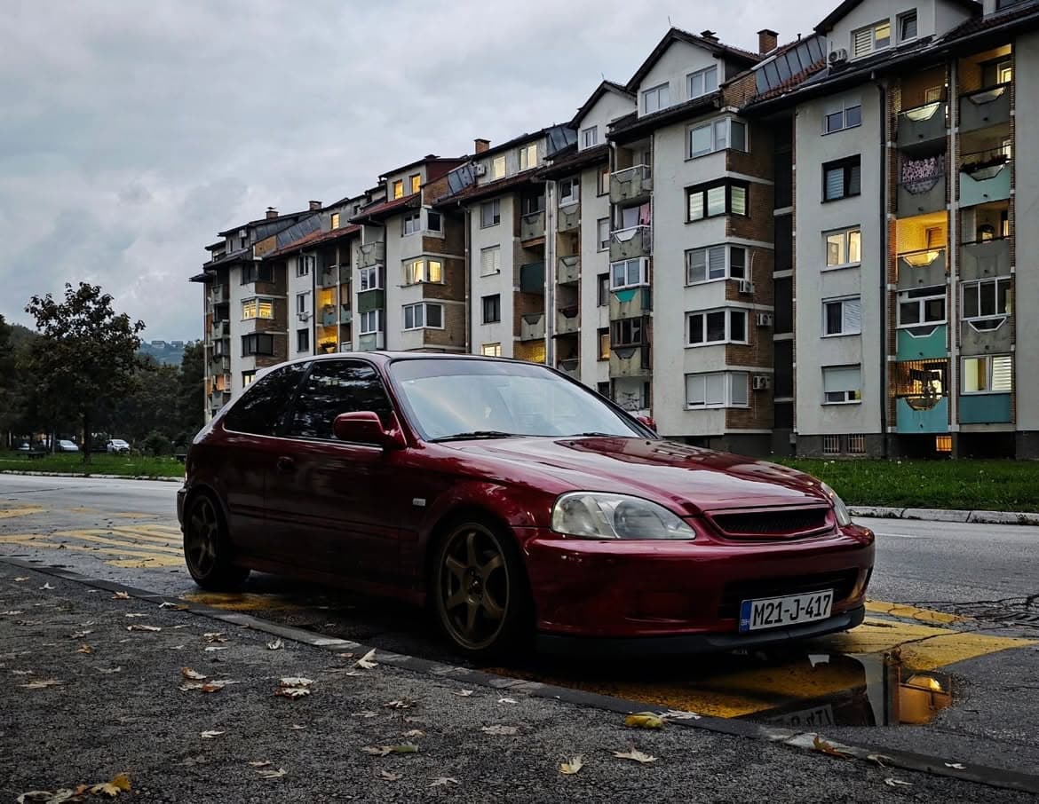 Tamnocrvena Honda Civic EK na bronzanim felgama, sarajevsko naselje u pozadini